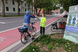Bild vergrößern: Bei der Sommerradl-Aktion verteilt die Fahrradbeauftragte der Stadt Ingolstadt, Theresa Schneider, Geschenke an die Radfahrer